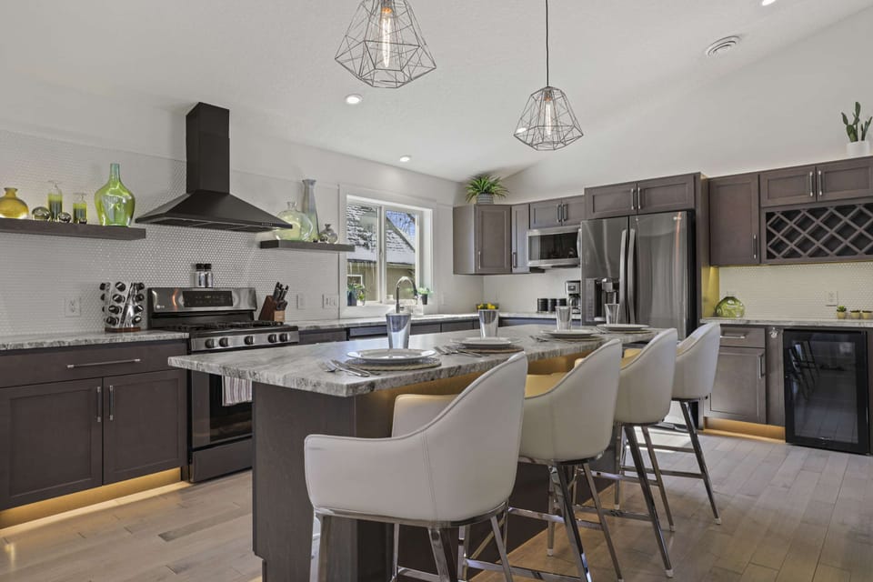 Fully stocked kitchen with 4 barstools at the island, complimentary coffee and tea station, and visibility to living and dining area.