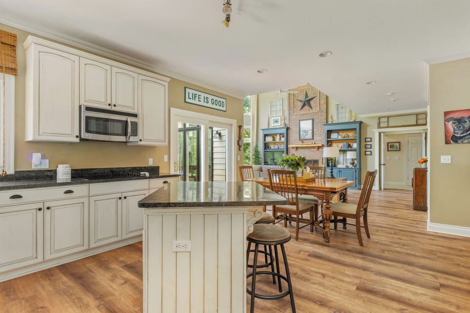 Kitchen with island seating and table for four. 
