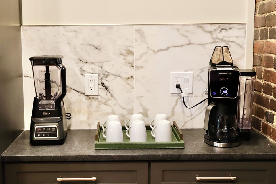 Stylish coffee station with blender, mugs, and sleek modern finishes