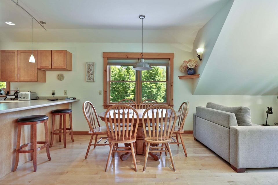 Meals stay connected to the conversation in an open layout joining the dining table, kitchen, and lounge.