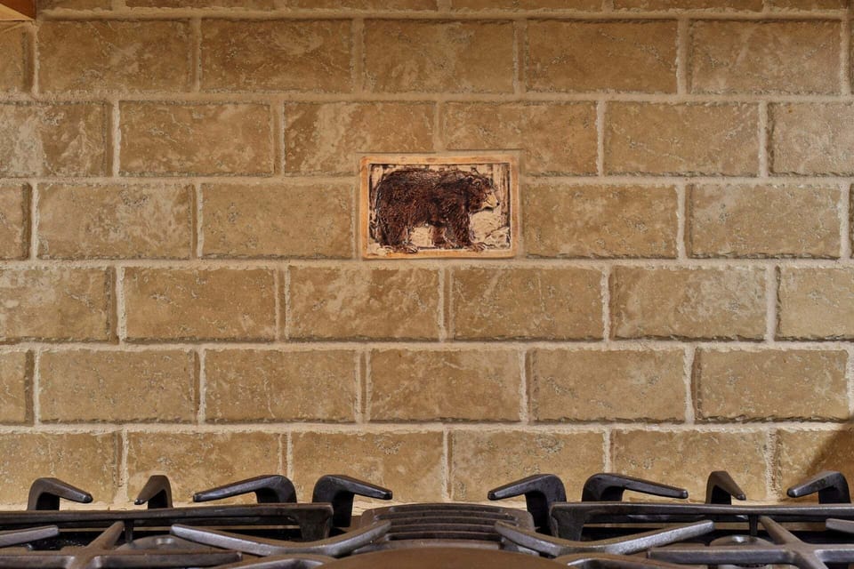 A small bear tile tucked into the stone backsplash adds a playful local touch.