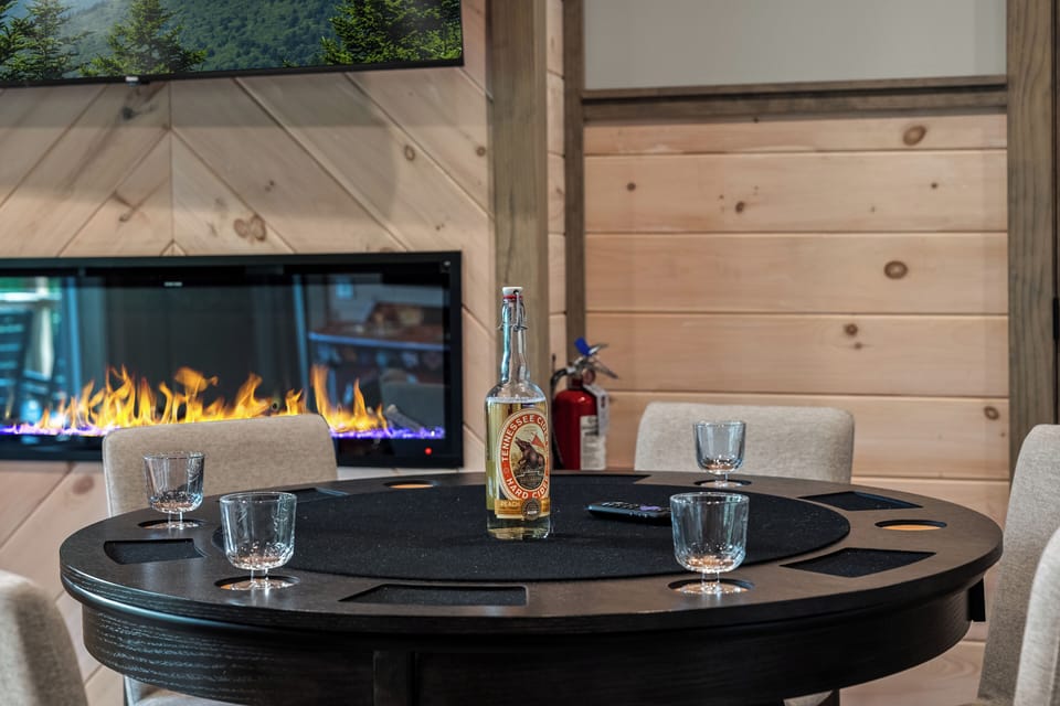 Poker table positioned beside an electric fireplace, offering a dedicated space for card games and indoor entertainment.