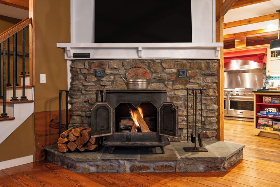 Floor-to-ceiling stone fireplace with a mounted TV above