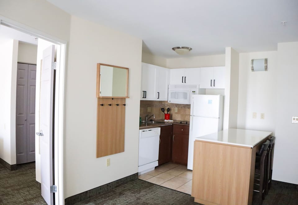 Kitchen with dining counter, refrigerator, and stove.
