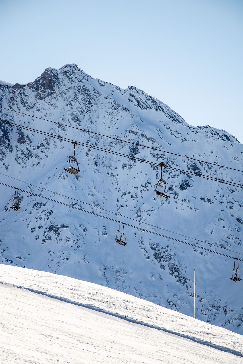 Ski lifts climbing a snow-covered mountainside above the resort