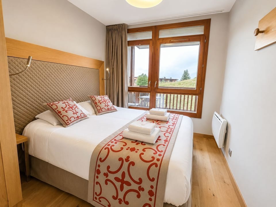 Twin beds dressed in red alpine-patterned throws, wood-paneled walls
