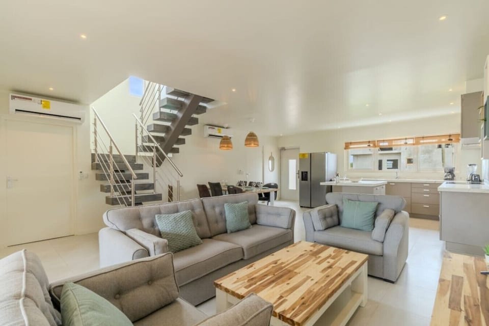 Villa Twin A’s bright open living room, with comfortable seating, a dining area, and a fully equipped kitchen.