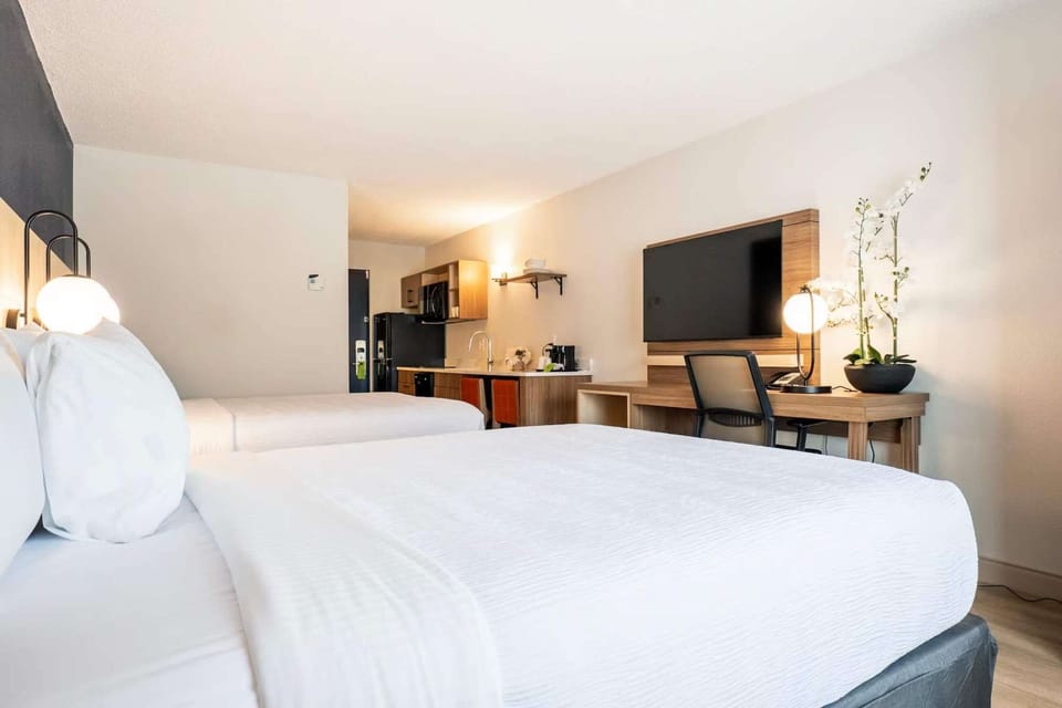 Two-bed room with TV, desk, kitchenette, and simple wood details