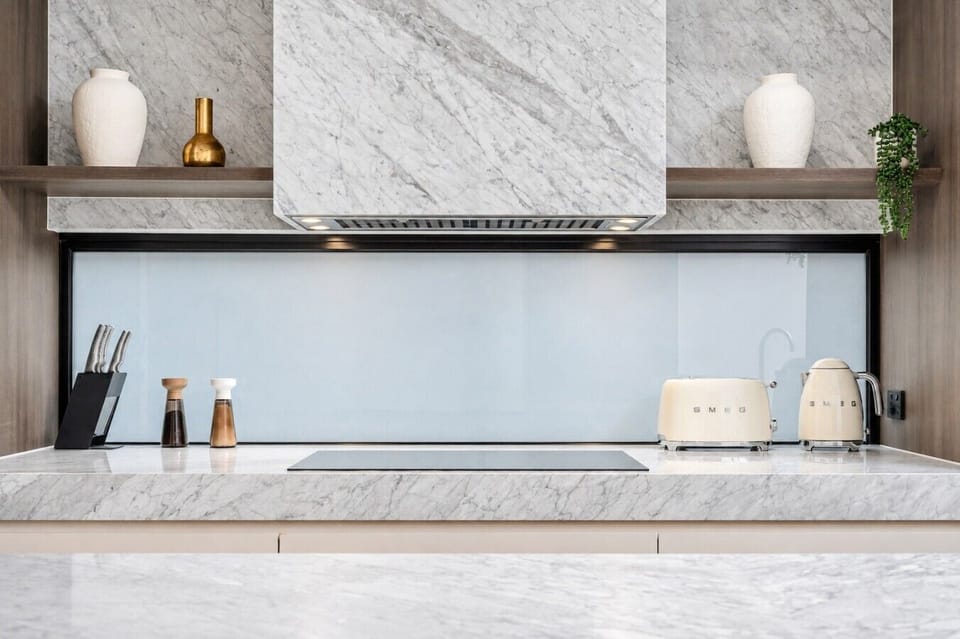 Marble surfaces and streamlined cabinetry define the beautifully finished kitchen