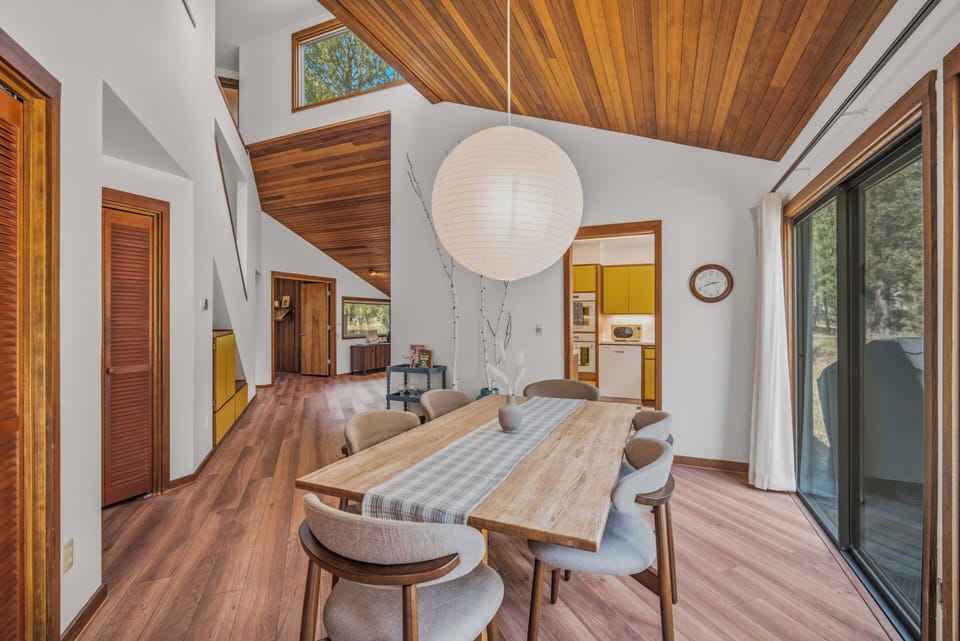 Your vacation retreat welcomes you with soaring wood-paneled ceilings and an open-concept living space flooded with natural light—perfect for gathering around the handcrafted dining table after a day of adventure.
