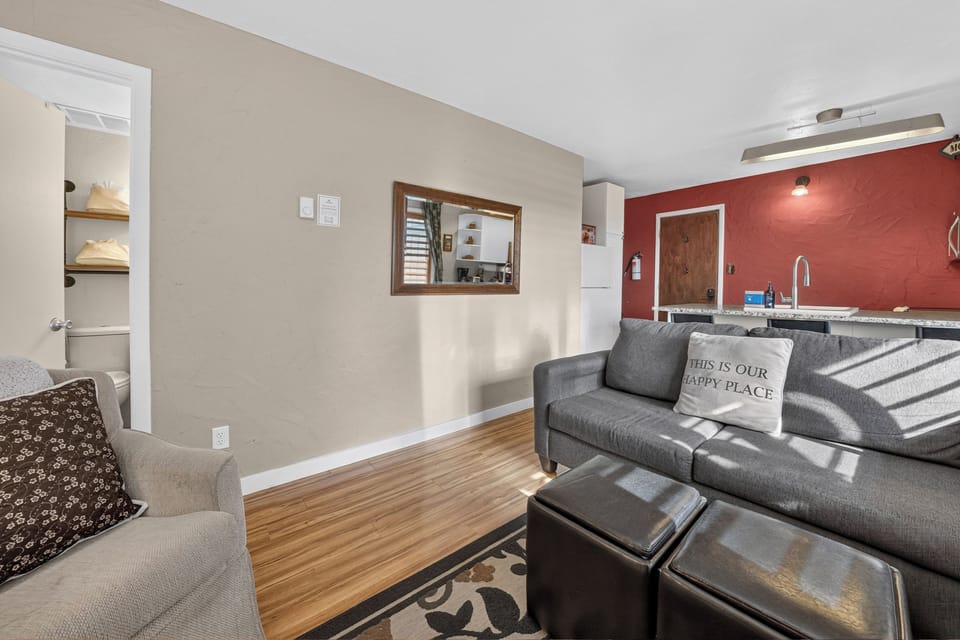 Settle into this bright, inviting living space where natural light and warm wood floors create your perfect home base. Modern comfort meets thoughtful design in this open layout.
