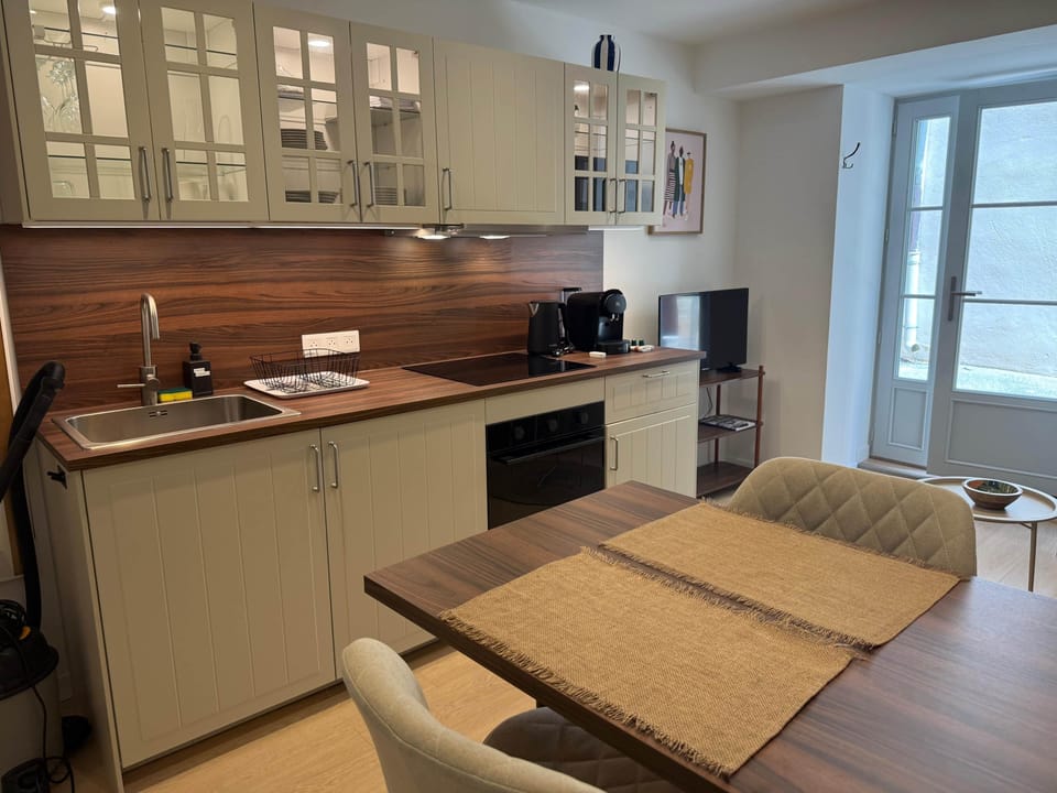 Dining area with equipped kitchen: oven, kettle and coffee machine.