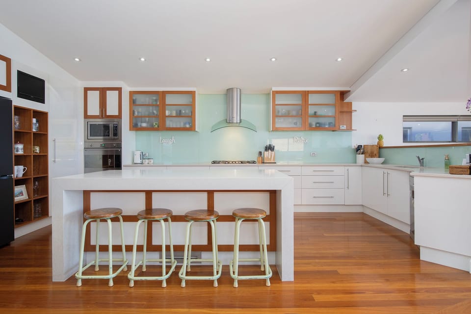 Pull up a stool at the expansive kitchen island, where generous preparation space and a social layout make cooking part of the holiday experience.