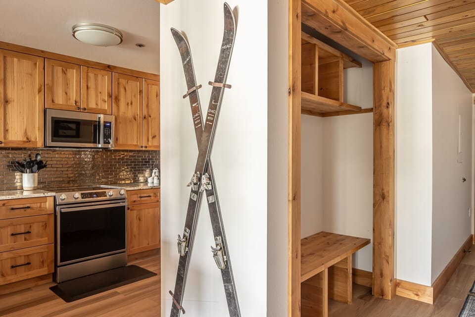 Warm wood accents and rustic ski decor welcome you into your mountain retreat, where a fully equipped kitchen and open shelving keep everything you need within easy reach.