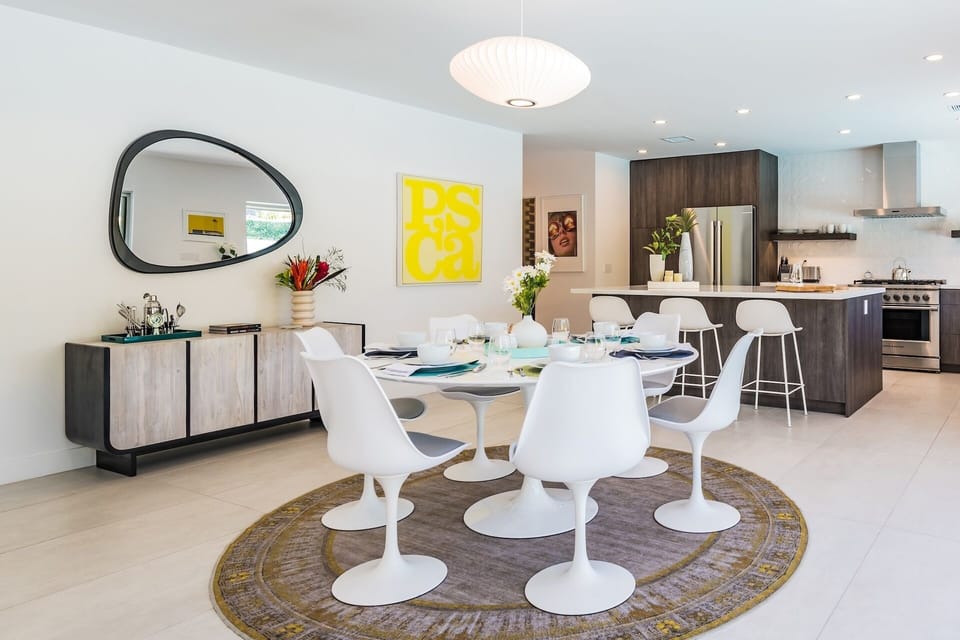 Gather around this sleek dining table in your open-concept space, where modern design meets warmth. The chef's kitchen flows seamlessly into your dining area, creating the perfect setting for memorable meals and conversations.