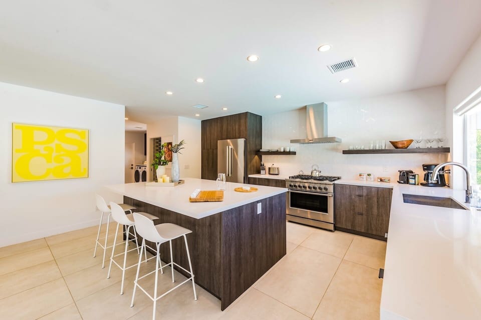 Step into your sleek, modern kitchen with rich wood cabinetry and a spacious island perfect for morning coffee or gathering with friends. Gleaming stainless appliances and open shelving invite your culinary creativity.