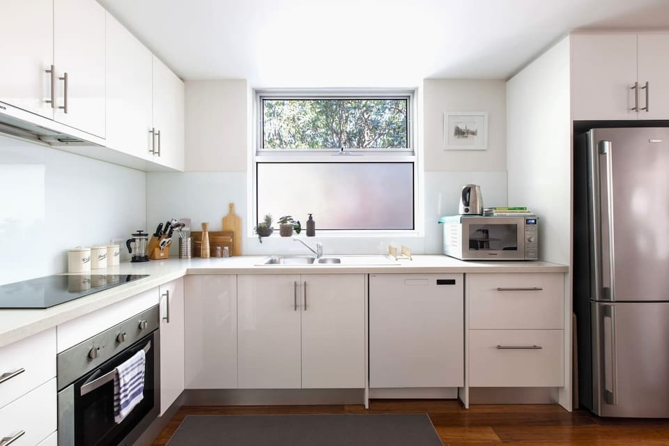 Whether you're whipping up a quick breakfast or experimenting with local ingredients, this modern kitchen is fully equipped with a Nespresso machine, full-sized fridge, oven, and dishwasher.