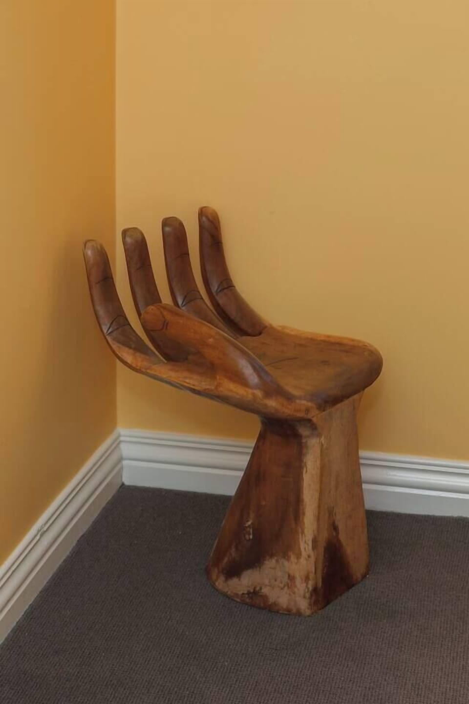 In the primary bedroom, the sculptural hand-shaped chair doubles as both a striking art piece and a cosy seating nook.