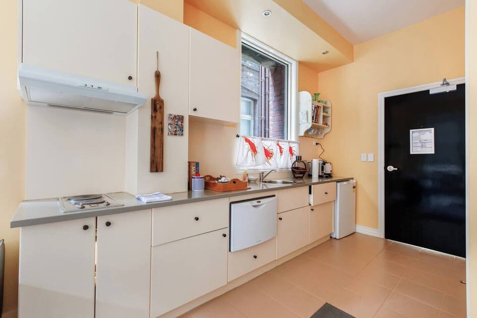 Whip up easy meals in the efficient kitchenette with a mini fridge, slimline dishwasher, cooktop, and lobster-print curtains for a playful touch.