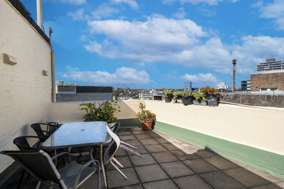 Enjoy a quiet moment on the building's shared rooftop, with outdoor seating and neighbourhood views.