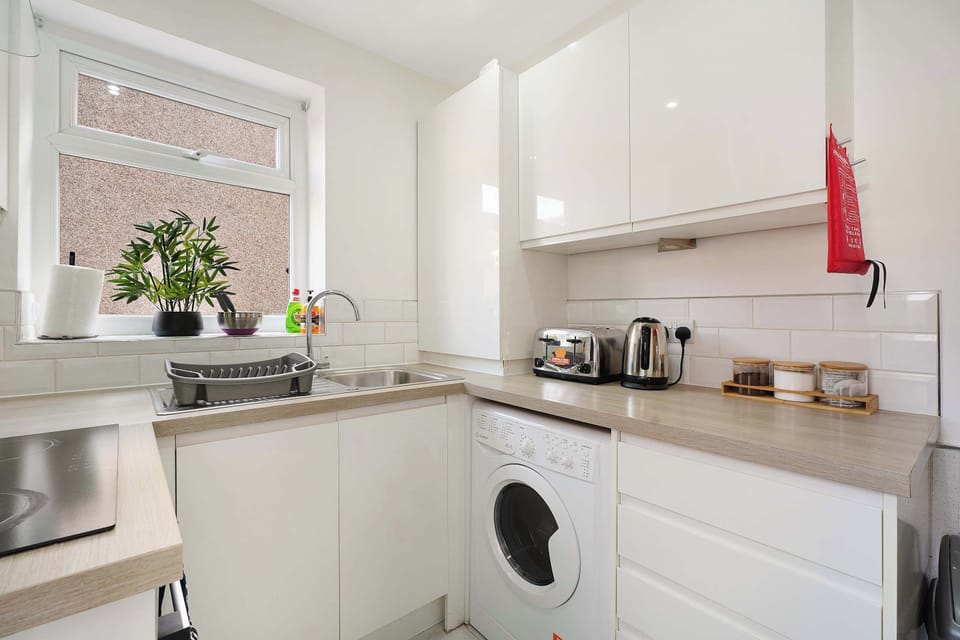 This practical kitchen includes an electric hob, oven, fridge/freezer, microwave, kettle and toaster, along with essential cookware and laundry facilities for a comfortable and convenient stay.