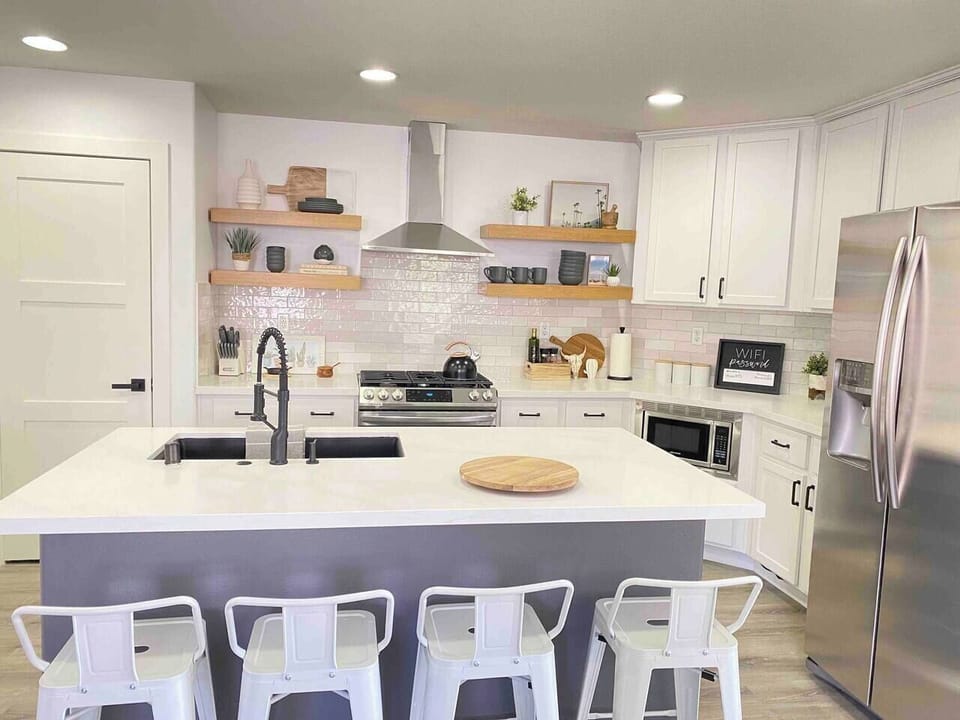 Spacious kitchen island with seating for four, ideal for breakfast, snacks, and gathering. There is also a dining table that seats 6 next to the pool table in the open living area.
