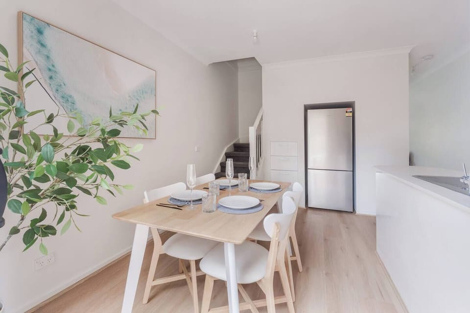 The dining area creates a warm gathering point with a timber table, comfortable seating and natural light that elevates slow breakfasts or relaxed evening meals.