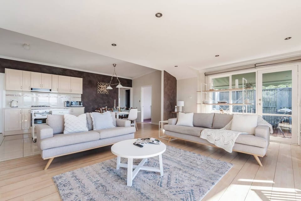 The open-plan layout connects the living, kitchen, and dining spaces effortlessly, creating a bright social hub for shared meals, movie nights, and easy holiday living.