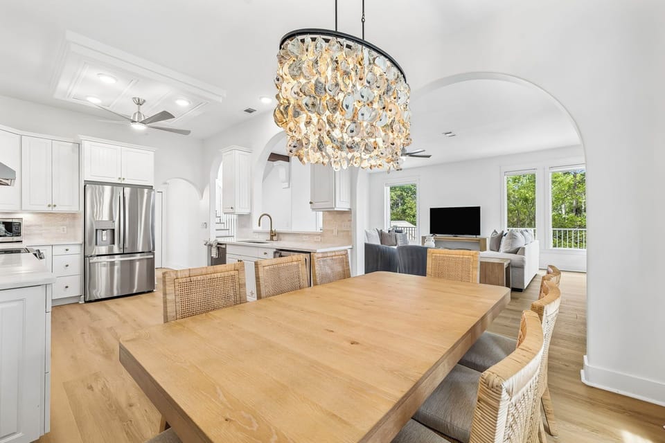 Gather around this spacious dining table under a stunning chandelier, with your gourmet kitchen and relaxing living area steps away—perfect for memorable meals and evening conversations.