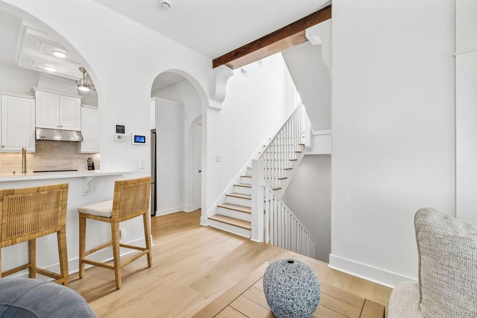 Light-filled open living spaces greet you as you arrive, with elegant archways and warm wood tones creating a relaxing coastal retreat. Your kitchen awaits just steps away, ready for morning coffee or evening gatherings.