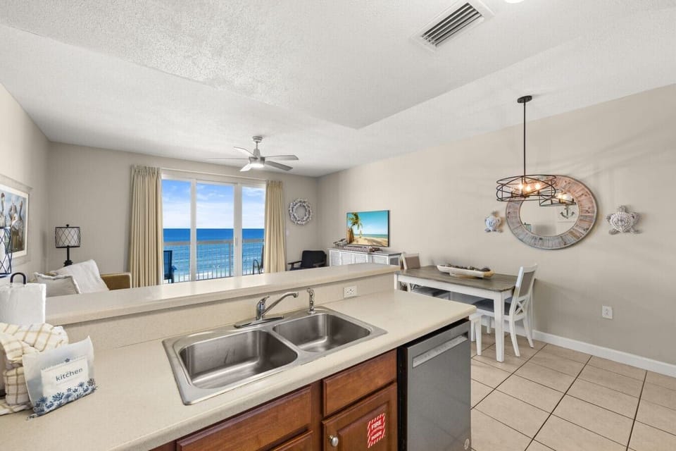 Share meals beside the living area at this coastal dining table, accented by nautical décor and a modern pendant light.