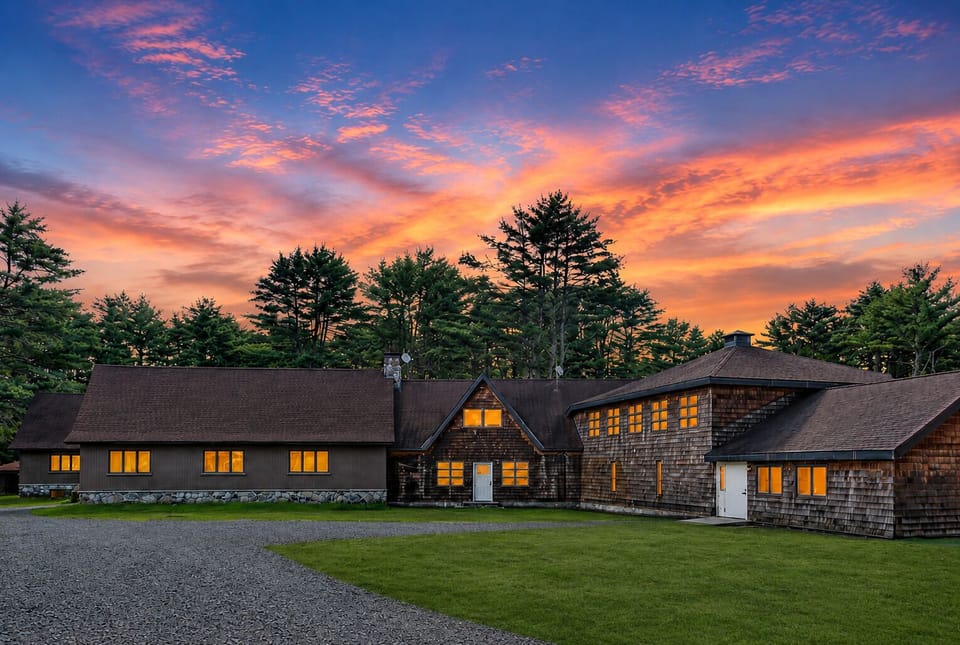 Rustic woodland retreat glowing beneath a stunning sunset sky