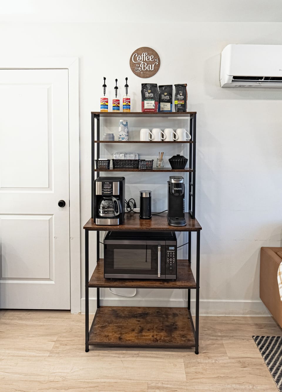 Cozy guest coffee bar with Keurig, microwave, mugs, and café essentials