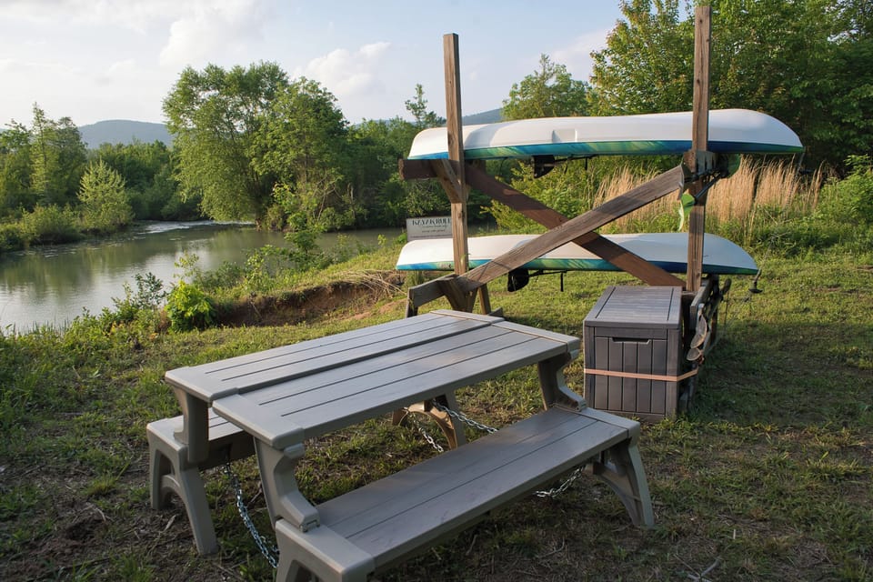 Kayaks and picnic seating are set up near the waterfront access area, reached by the private trail on the property.