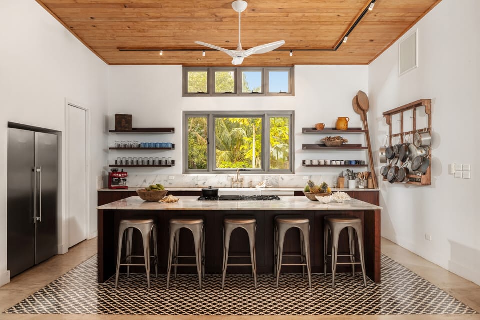 Bright designer kitchen with large island seating and tropical views
