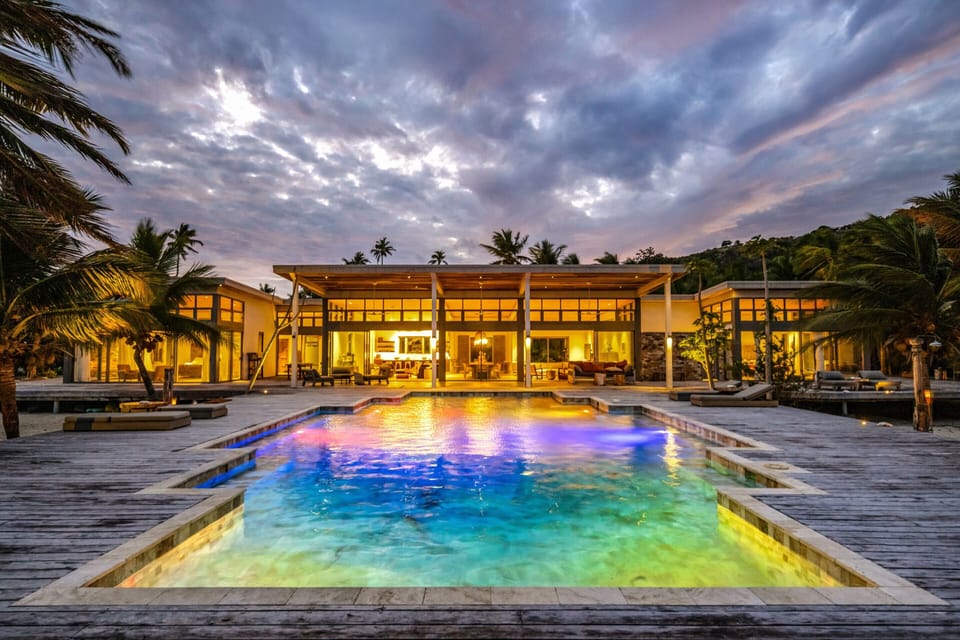 Luxury tropical villa with glowing pool, sunset views, and resort-style outdoor living