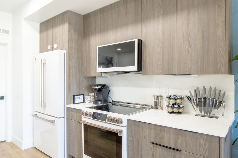 Compact kitchen with wood grain cabinetry.