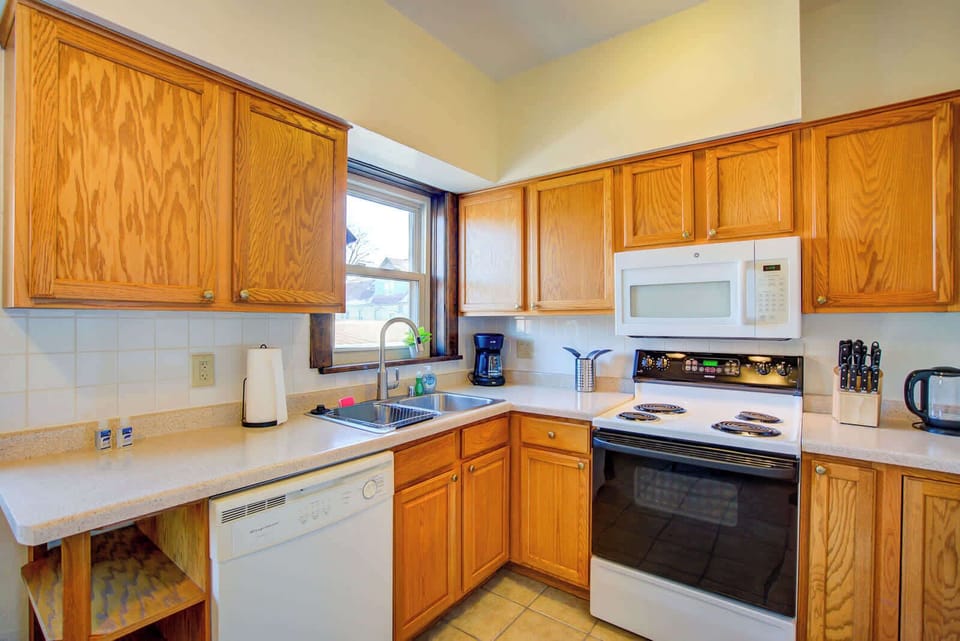 Functional kitchen with ample cabinet storage, full-size appliances, coffee maker, and dishwasher—equipped to make meal prep and daily living simple and convenient for extended stays.