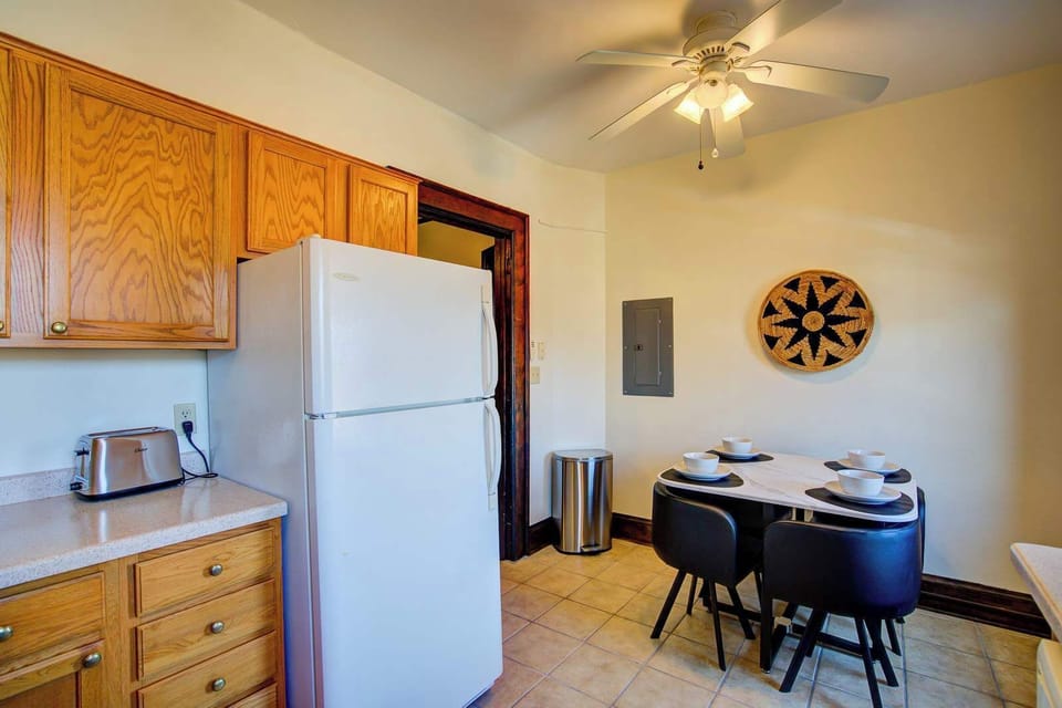 Spacious kitchen complete with a full-sized refrigerator, generous cabinetry, and a dining area for four—perfect for daily meals, work breaks, or hosting a casual dinner during a longer stay.