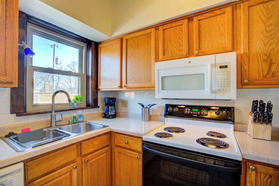 Fully equipped kitchen featuring a full-size stove, microwave, coffee maker, and knife set, with ample counter space and storage to support everyday cooking and long-term living.