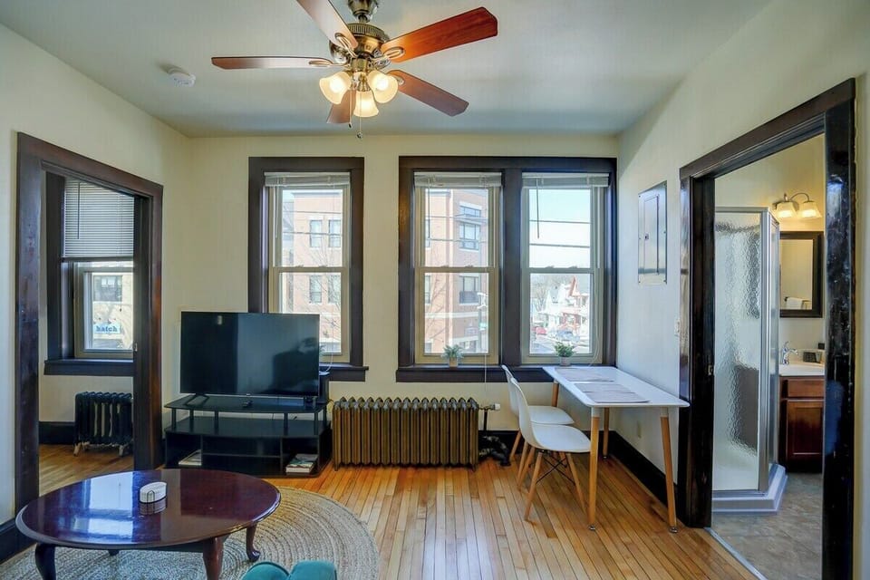 Living room with sofa, entertainment center and workspace facing Willy St