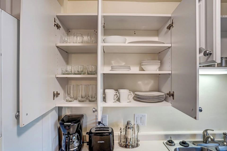 Kitchen complete with coffee maker, toaster, and tableware.