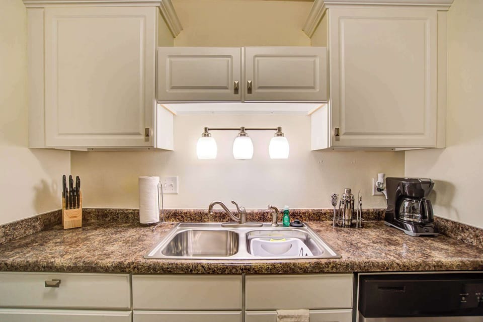 Bright, modern kitchen setup with double sink, coffee maker, and ample counter space—perfect for cooking or morning coffee.