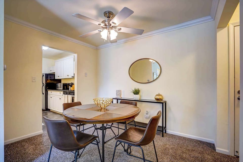 Cozy dining area with seating for four, stylish decor, and a ceiling fan for comfort—perfect for meals or casual gatherings.