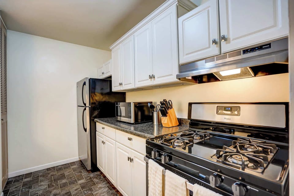 Modern galley kitchen featuring sleek stainless steel appliances, granite-style countertops, and crisp white cabinetry for a clean, contemporary look.