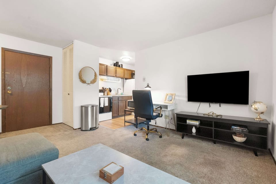 Functional workspace featuring a sleek desk, ergonomic chair, and mounted TV for focus or downtime. Perfect for remote work or study in a quiet, comfortable setting.