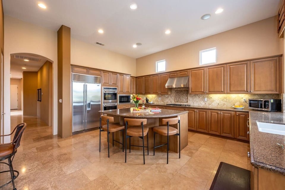 Fully stocked kitchen: stainless steel appliances and large island, 3 bar stools, designated work desk and chair, walk-in pantry, kitchen nook with 5-person round table