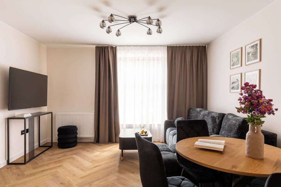 Salon stanowi komfortową przestrzeń do wypoczynku. Znajduje się w nim wygodna, rozkładana sofa zapewniająca dodatkowe miejsce do spania, stolik kawowy oraz telewizor Smart TV z dostępem do kanałów satelitarnych. 