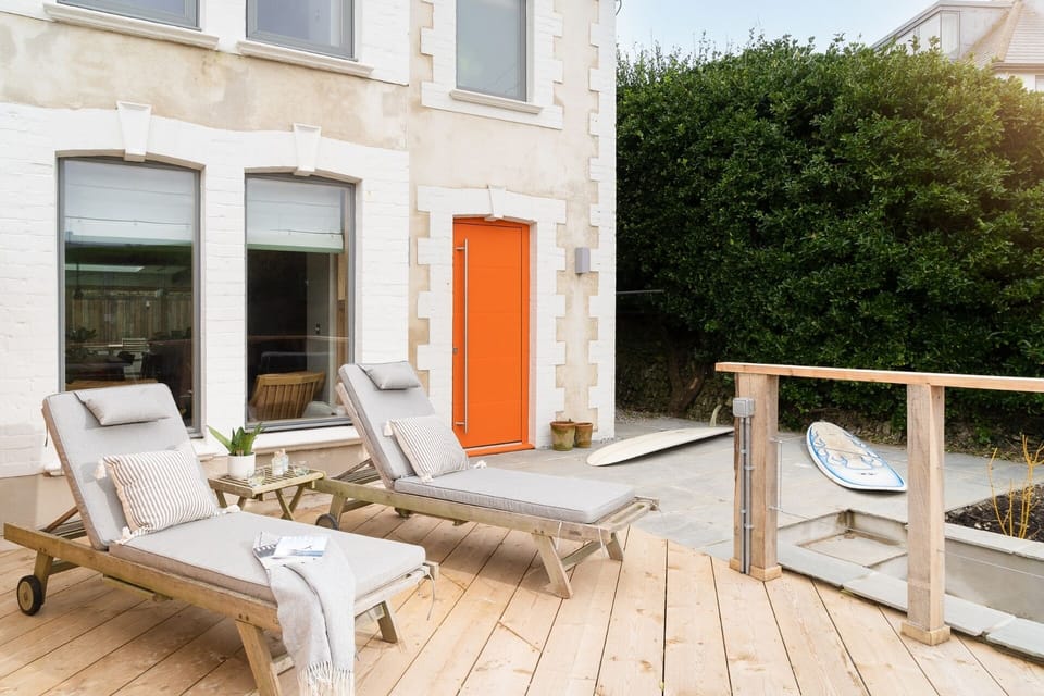 Front deck with sun loungers and surfboards at Beachspace Crantock