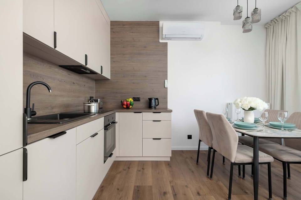 Bright kitchen with a dining table, comfortable chairs, and large windows.